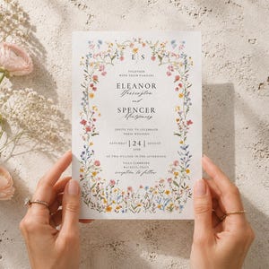 Bride holding editable wildflower wedding invitation printed on premium textured cardstock, showing realistic size, paper texture and floral artwork.
