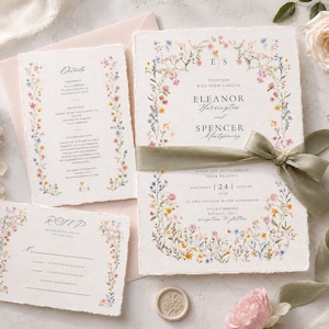 Luxury wildflower wedding invitation suite styled with a sage ribbon, blush envelope and fresh garden flowers, showing the editable invitation, RSVP and wedding details cards.