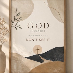 Peut inclure: Une affiche murale rectangulaire dans un cadre en bois avec le texte GOD IS WORKING EVEN WHEN YOU DON'T SEE IT. Le design présente des formes abstraites beiges, brunes et noires, une petite branche feuillue et une silhouette de croix.