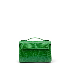 Peut inclure: Un sac à main vert vif avec un motif texturé en forme de peau de crocodile. Il est doté d'une poignée supérieure et d'une fermeture à rabat. Un accessoire saisissant, parfait pour ajouter une touche de couleur à n'importe quelle tenue.