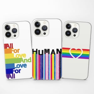Puede incluir: Tres fundas blancas para teléfono con diferentes diseños. Una funda tiene un arcoíris y las palabras "All For Love And Love For All". Otra tiene la palabra "HUMAN" sobre rayas verticales coloridas. La tercera funda presenta un corazón arcoíris.