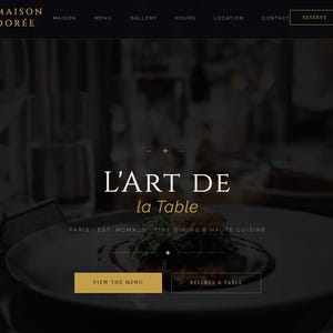 May include: A website landing page for Maison Dorée featuring a dark background with gold text. The header includes navigation links and a reserve button. The center displays the text L'ART DE la Table, Paris, Est MCMXCII, Fine Dining & Haute Cuisine, with two buttons below labeled View The Menu and Reserve A Table.