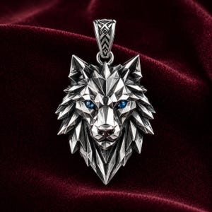 May include: A silver-toned pendant shaped like a geometric wolf head with sharp, faceted edges and two small, round, bright blue stones set as eyes. The pendant features a detailed, textured bail at the top for attaching to a chain.