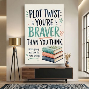 May include: A vertical wall art print featuring the text "PLOT TWIST: YOU'RE BRAVER THAN YOU THINK." and "Keep going. You can do hard things." above an illustration of three stacked books in teal, coral, and navy blue with a small heart and star.