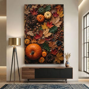 Pode incluir: Uma impressão de arte de parede vertical apresentando um arranjo denso de elementos de outono, incluindo uma grande abóbora laranja, abóboras menores em laranja, verde e branco, pinhas castanhas, bolotas, bagas e folhas caídas de ácer e carvalho.
