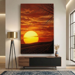 Könnte beinhalten: Ein großes rechteckiges Gemälde zeigt einen Sonnenuntergang über einem Feld. Die Sonne ist eine leuchtend gelbe Kugel, und der Himmel ist eine Mischung aus Orange und Rot. Silhouetten von Vögeln fliegen über den Himmel. Ein Baum befindet sich auf der rechten Seite.