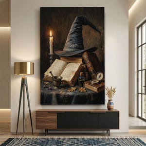 May include: A vertical wall art print depicting a dark pointed hat resting on a stack of aged leather-bound books. An open book with handwritten text, a lit candle in a silver holder, a mortar and pestle, a small glass bottle, and a compass.