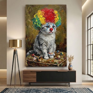 Può includere: Un grande dipinto verticale raffigura un gatto grigio vestito da clown. Il gatto indossa una parrucca colorata, un naso rosso e trucco blu sugli occhi. È seduto su un cuscino fantasia con giocattoli e una tromba. Lo sfondo è verde oliva strutturato.