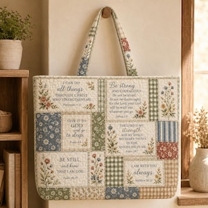 May include: A quilted tote bag featuring a patchwork design of floral patterns, green and blue gingham, and striped fabric. The bag displays several religious quotes including Philippians 4:13, Joshua 1:9, Psalm 4:8, Psalm 28:7, Psalm 46:10, and Matthew 28:20.