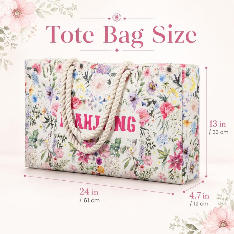 May include: A rectangular tote bag with a white base and a colorful floral pattern featuring pink, blue, and yellow flowers. The bag has thick, cream-colored rope handles and the word MAHJONG printed in pink. Dimensions are 24 inches by 13 inches by 4.7 inches.