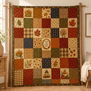 May include: A patchwork quilt featuring a grid of squares with autumn-themed patterns including maple leaves, pumpkins, plaid, and floral prints. The center square displays a wreath design with the text Fall is my favorite color.