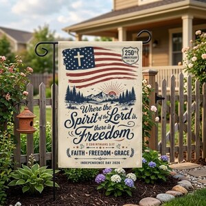 Könnte beinhalten: Eine rechteckige Gartenflagge mit einer stilisierten amerikanischen Flagge mit einem weißen Kreuz im blauen Feld. Darunter eine Berglandschaft mit Kiefern und einer Sonne. Der Text lautet: Where the Spirit of the Lord is, there is Freedom, 2 Corinthians 3:17, Faith Freedom Grace, Independence Day 2026 und 250th Anniversary 1776-2026.