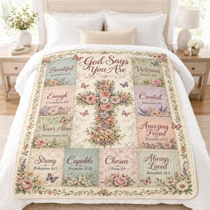 Peut inclure: Une courtepointe couleur crème ornée d'une croix florale centrale et du texte God Says You Are, entourée de panneaux rectangulaires à motifs floraux, de papillons et de phrases inspirantes comme Beautiful, Enough et Strong avec des versets bibliques.