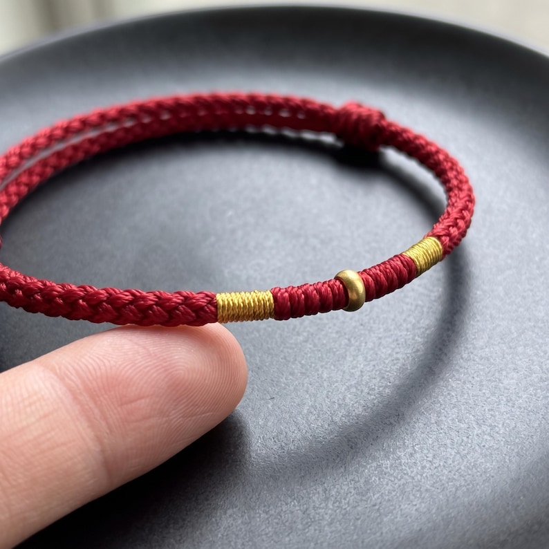 Pulsera ajustable de cordón trenzado con detalles en oro puro de 24 quilates. imagen 13