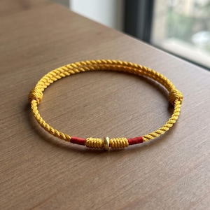 Pulsera ajustable de cordón trenzado con detalles en oro puro de 24 quilates. Amarillo