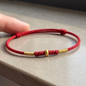 Pulsera ajustable de cordón trenzado con detalles en oro puro de 24 quilates. imagen 14