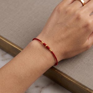 Pulsera ajustable de cordón trenzado con detalles en oro puro de 24 quilates. imagen 2