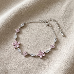 Blommigt armband med rosa blomberlocker och guld- eller silvertoning