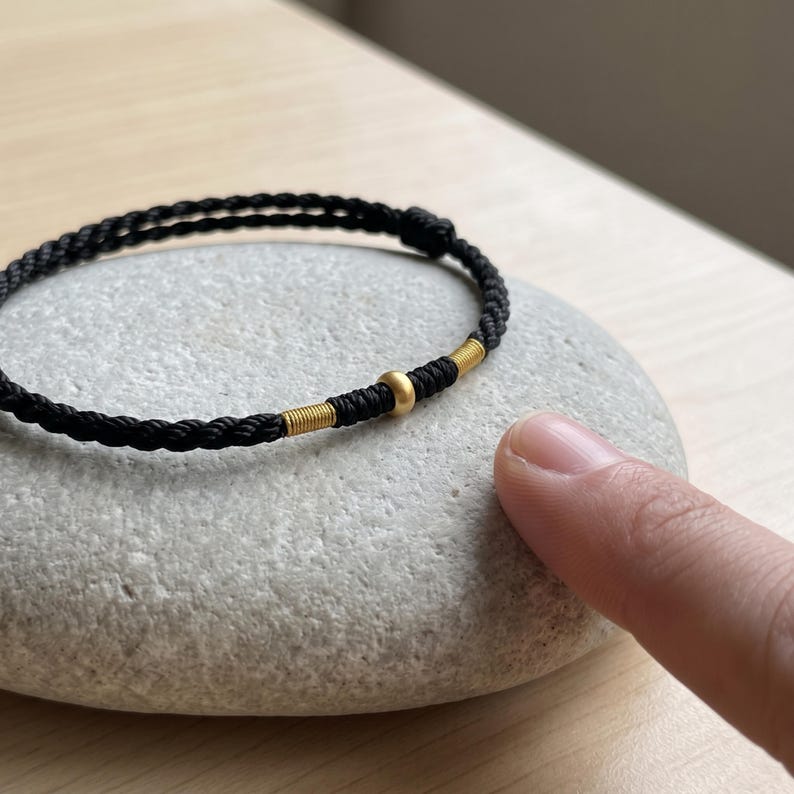 Pulsera ajustable de cordón trenzado con detalles en oro puro de 24 quilates. Negro