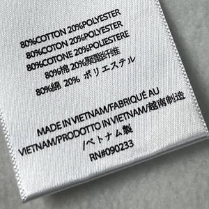 Puede incluir: Primer plano de una etiqueta de tela blanca con texto negro. La etiqueta indica la composici&oacute;n de la tela: 80% algod&oacute;n y 20% poli&eacute;ster en varios idiomas. Tambi&eacute;n indica 'Hecho en Vietnam'. RN #090233.