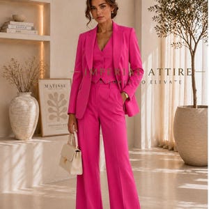 May include: A vibrant hot pink three-piece suit consisting of a tailored blazer, a button-up vest, and wide-leg trousers. The ensemble is paired with a small cream-colored structured handbag and pointed-toe shoes. Text reads IMPERIAL ATTIRE.
