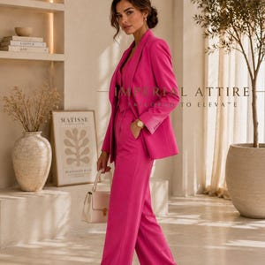May include: A vibrant hot pink blazer and matching wide-leg trousers set. The blazer features a notched lapel and long sleeves. The trousers have a high-waisted fit. The text IMPERIAL ATTIRE TAILORED TO ELEVATE is visible in the center of the image.