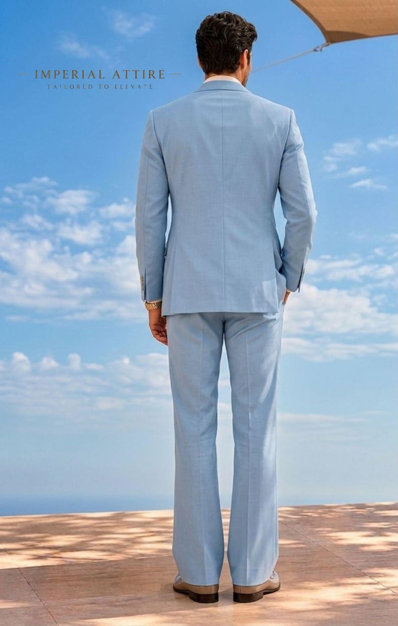 May include: A light blue suit, including a blazer and trousers, is shown from the back against a blue sky with clouds. The suit is tailored and has a classic design. The text "IMPERIAL ATTIRE - TAILORED TO ELEVATE" is visible at the top.