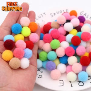 May include: A collection of colorful pom-poms in various shades, including pink, blue, yellow, and orange. The pom-poms are small, round, and fluffy, with a soft texture. The image also includes the text "FREE SHIPPING".