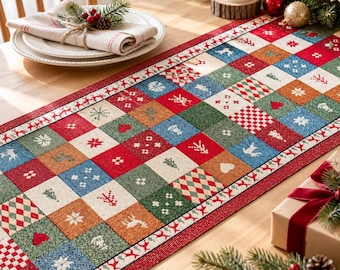 Puede incluir: Un camino de mesa rectangular con un patrón de patchwork de cuadrados rojos, verdes, azules y naranjas. Cada cuadrado muestra iconos navideños blancos que incluyen renos, pinos, copos de nieve, corazones y motivos de diamantes.