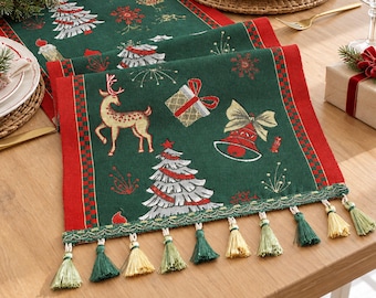 Puede incluir: Un camino de mesa rectangular de color verde oscuro con un patrón festivo de renos dorados, árboles de Navidad plateados, campanas rojas y regalos. Tiene bordes rojos con un ribete a cuadros y está rematado con borlas doradas y verdes.