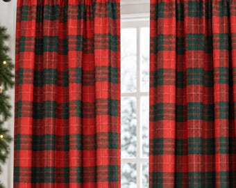 Puede incluir: Un par de cortinas de cuerpo entero con un patrón de cuadros en rojo y verde oscuro. La tela tiene una textura tejida visible y cuelga de una barra marrón oscura con un bolsillo para la barra. Las cortinas están fruncidas en pliegues.