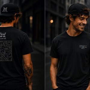 May include: A black t-shirt and matching baseball cap. The back of the shirt features a graphic of a cat head above the text SCAN ME and a large QR code. The front of the shirt displays the text PROJECT BLU. The cap features a small cat logo.