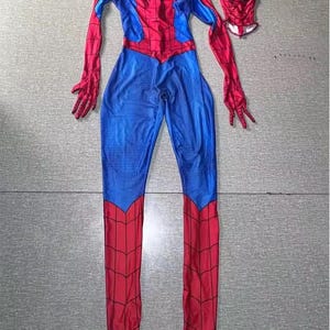 May include: A red and blue Spider-Man costume, comprising a full body suit and a separate mask. The suit has a red spider web pattern on the red areas and blue panels on the torso and legs. The mask features white eye coverings.