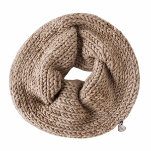 May include: A beige infinity scarf featuring a chunky knit texture with a braided pattern. The circular scarf includes a small, metallic, heart-shaped charm attached to the lower edge, adding a subtle detail to the overall knitted design.