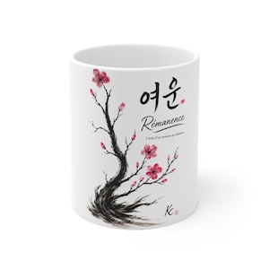 May include: A white ceramic mug featuring a black ink-style illustration of a flowering cherry blossom branch with pink petals. The text reads "여운", "Rémanence", and "L'écho d'un moment qui demeure" in black, with a small "Kc" signature at the bottom.