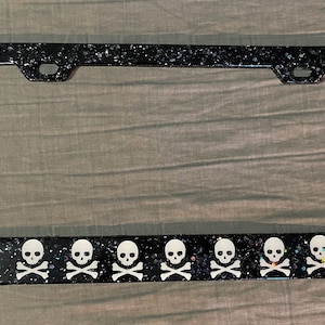 Black and silver glitter license plate frame with skulls