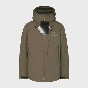 May include: A khaki-coloured hooded jacket with a zip closure and multiple pockets. The jacket has a brand logo on the chest and a tag attached to the zip. The jacket is designed for outdoor activities.