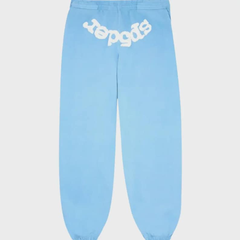 May include: Light blue sweatpants with the word "spider" in white, arched across the back waistband. The pants have a relaxed fit and a drawstring waist. The fabric appears to be a lightweight material.