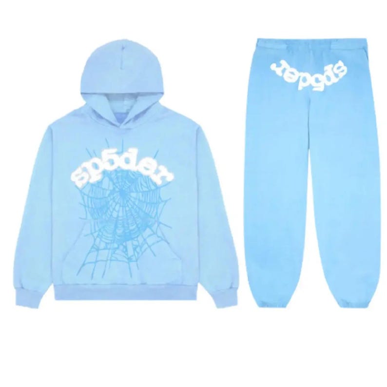 May include: A light blue hoodie and matching sweatpants set. The hoodie features a white "sp5der" logo above a spiderweb design. The sweatpants also have the "sp5der" logo in white on the back. The set is made of a soft material.