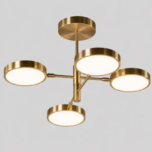 Puede incluir: Una lámpara de techo con acabado en latón que presenta una varilla vertical central conectada a cuatro brazos horizontales. Cada brazo sostiene un panel de luz circular y plano con un difusor blanco, creando una disposición de iluminación equilibrada.