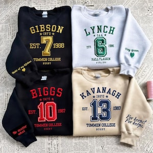 May include: A collection of crewneck sweatshirts in black, grey, and tan. Each sweatshirt features embroidered text with names, numbers, and the text "Tommen College Rugby". Some sleeves have additional text like "Hey queen" and "For keeps?"