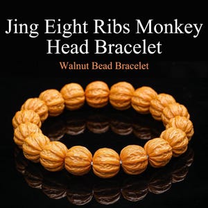 May include: A bracelet made of walnut beads. The beads are carved to resemble monkey heads. The text on the image reads "Jing Eight Ribs Monkey Head Bracelet" and "Walnut Bead Bracelet". The bracelet is a light brown color and is displayed on a black surface.
