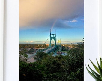 May include: A framed photograph of a green bridge with a rainbow in the sky. The bridge is surrounded by trees and the city skyline is visible in the background.