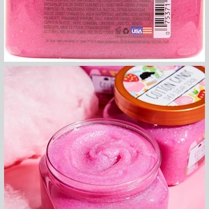 Puede incluir: Primer plano de dos tarros de exfoliante de az&uacute;car de karit&eacute; Cotton Candy de Tree Hut, de color rosa. Los tarros son transparentes con una tapa marr&oacute;n y una etiqueta que dice "Cotton Candy Shea Sugar Scrub".