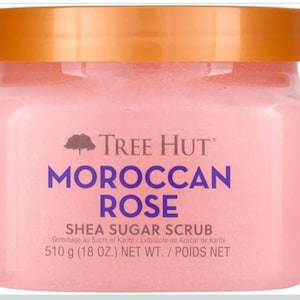 Puede incluir: Un tarro rosa de exfoliante de az&uacute;car y karit&eacute; Tree Hut Moroccan Rose con tapa dorada. El nombre del producto est&aacute; en morado. El tarro contiene 510g de producto.