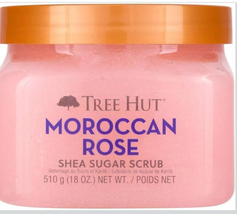 Puede incluir: Un tarro rosa de exfoliante de az&uacute;car y karit&eacute; Tree Hut Moroccan Rose con tapa dorada. El nombre del producto est&aacute; en morado. El tarro contiene 510g de producto.