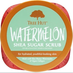 Puede incluir: Un recipiente redondo de exfoliante de az&uacute;car de karit&eacute; de sand&iacute;a Tree Hut. El recipiente tiene una base roja, un borde naranja y una etiqueta verde claro con las palabras "WATERMELON" y "SHEA SUGAR SCRUB". La etiqueta tambi&eacute;n indica "para una piel hidratada y de aspecto juvenil".