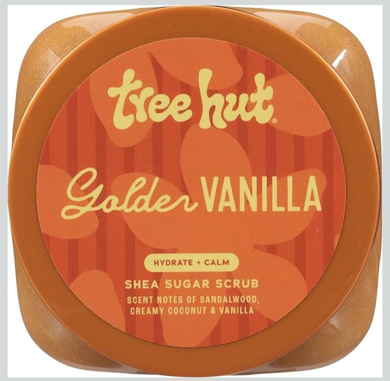 Puede incluir: Un tarro de exfoliante de az&uacute;car de karit&eacute; Tree Hut Golden Vanilla. La etiqueta es naranja y presenta el nombre de la marca y del producto en una fuente estilizada. La etiqueta tambi&eacute;n incluye las frases "Hydrate + Calm" y "Notas de aroma de s&aacute;ndalo, coco cremoso y vainilla."