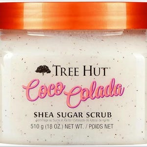 Puede incluir: Un tarro de exfoliante de az&uacute;car de karit&eacute; Coco Colada de Tree Hut. El exfoliante blanco est&aacute; salpicado de motas oscuras y tiene una tapa de color naranja brillante. La etiqueta muestra el nombre de la marca, el nombre del producto y el peso neto de 510 g.