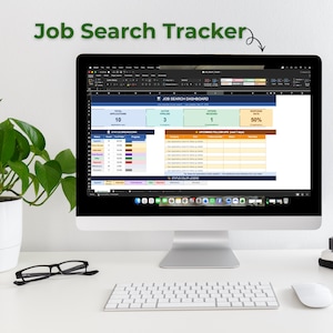 May include: A computer monitor displays a spreadsheet titled "Job Search Tracker." The spreadsheet shows data on job applications, active pipelines, offers received, and response rates. A keyboard, mouse, and glasses are on the desk.